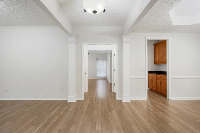 a view of empty room with wooden floor