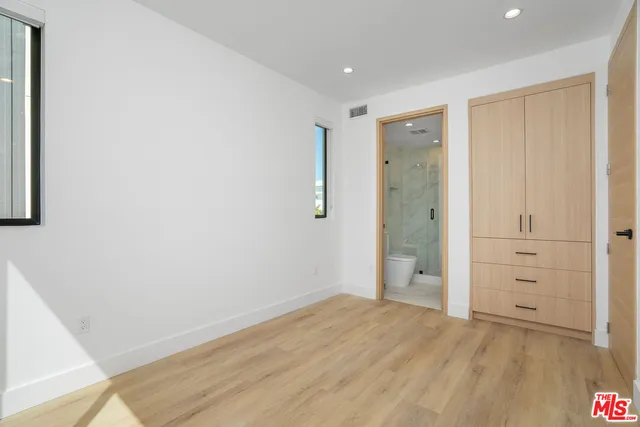 an empty room with closet and wooden floor