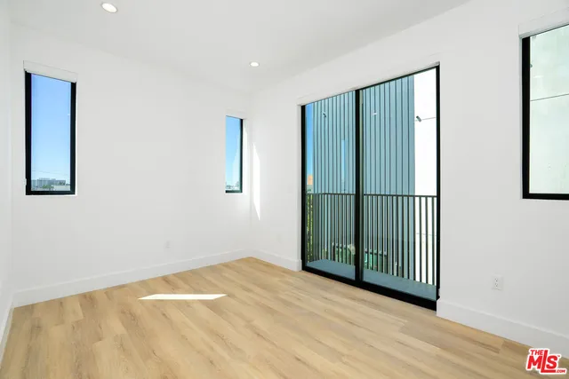 a view of a hallway with wooden floor and a window