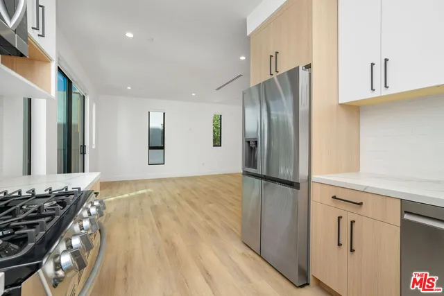 a kitchen with stainless steel appliances granite countertop a refrigerator and a stove