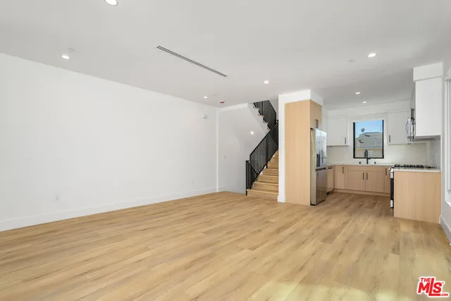 a view of a kitchen with a sink and a refrigerator