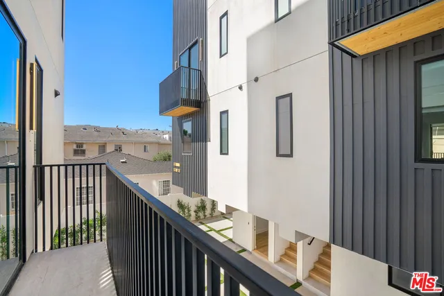 a balcony with view of wooden floor and a potted plant