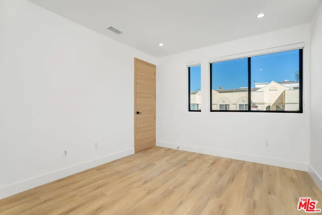 a view of a room with wooden floor and a window