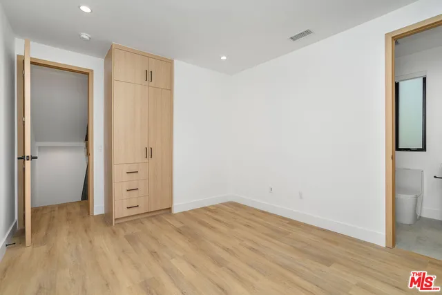 an empty room with wooden floor and closet