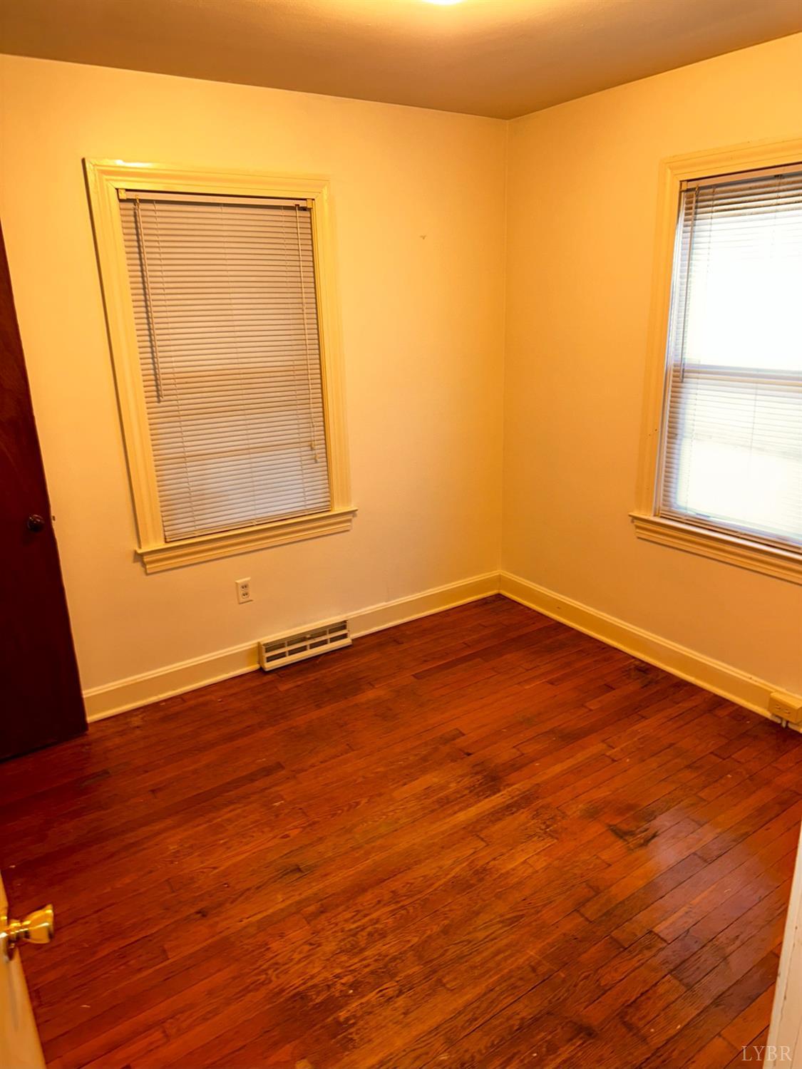1724 Stone Mill Road Hurt, VA 24563 - Photo 30 of 37 an empty room with wooden floor and windows
