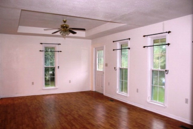 204 Hickman Road Forsyth, GA 31029 - Photo 4 of 13 a view of an empty room with a window and wooden floor