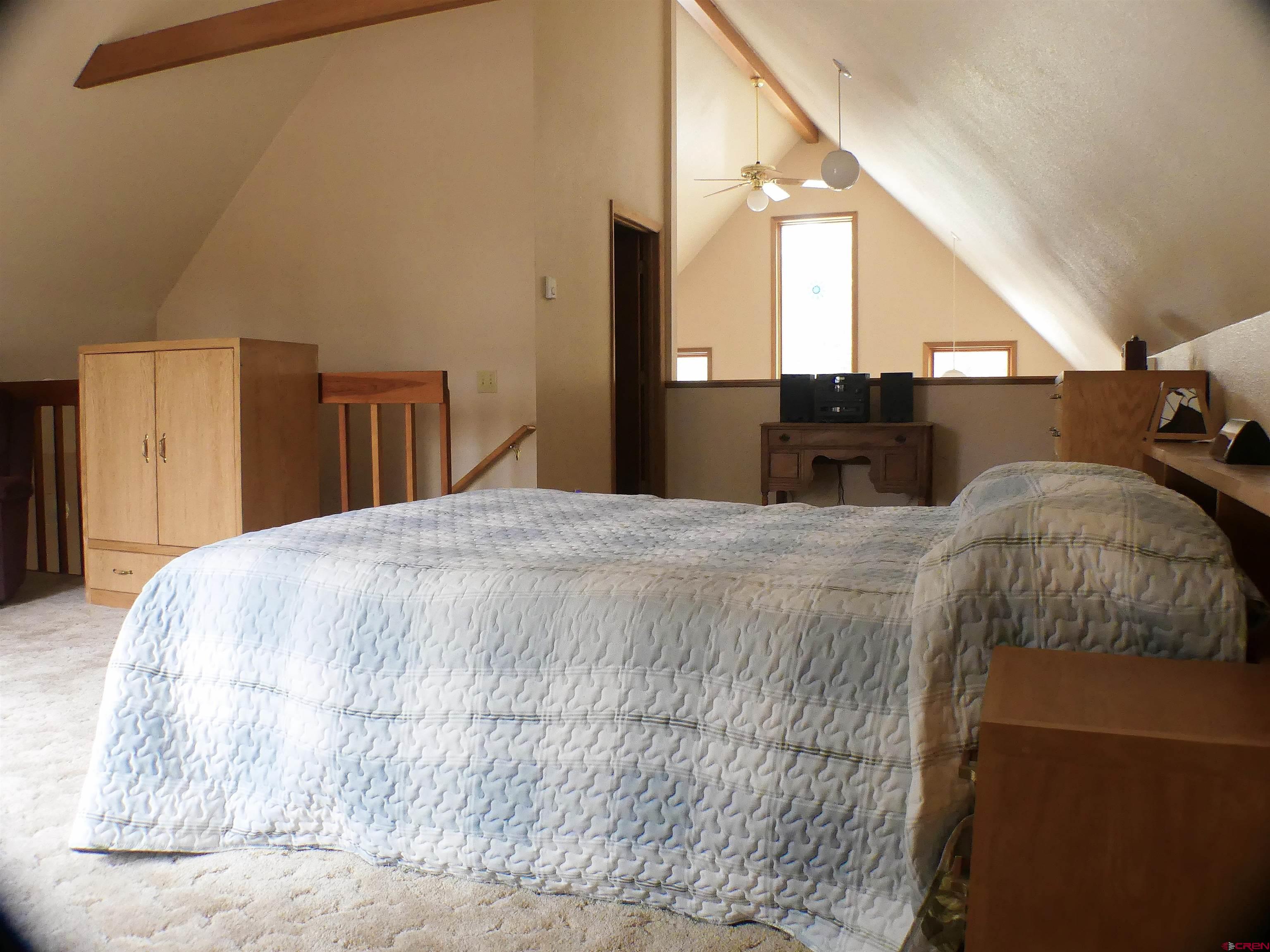 453 Ute Road Cimarron, CO 81220 - Photo 11 of 18 a large bed sitting in a bedroom next to a bathroom