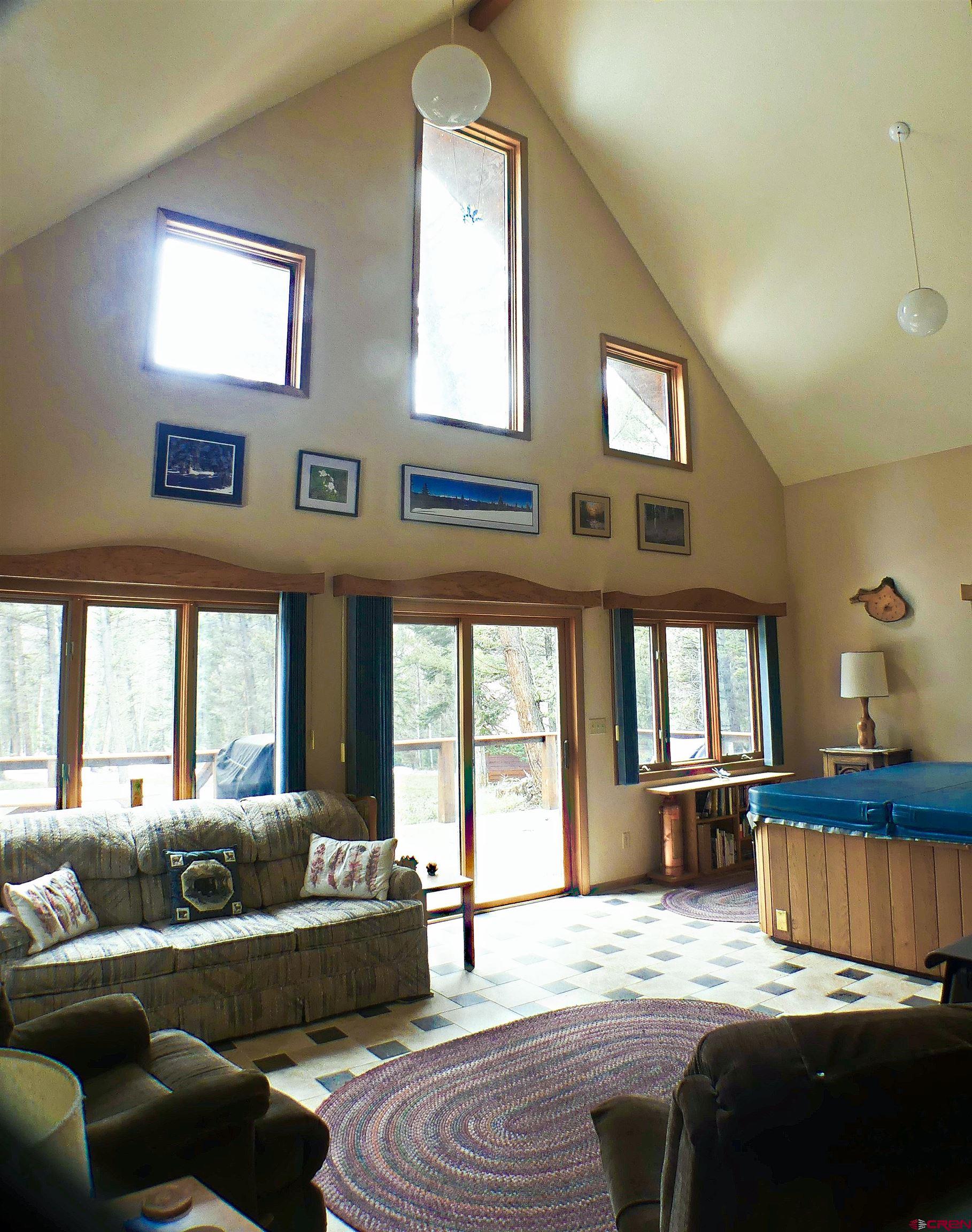 453 Ute Road Cimarron, CO 81220 - Photo 3 of 18 a bedroom with a bed and glass windows