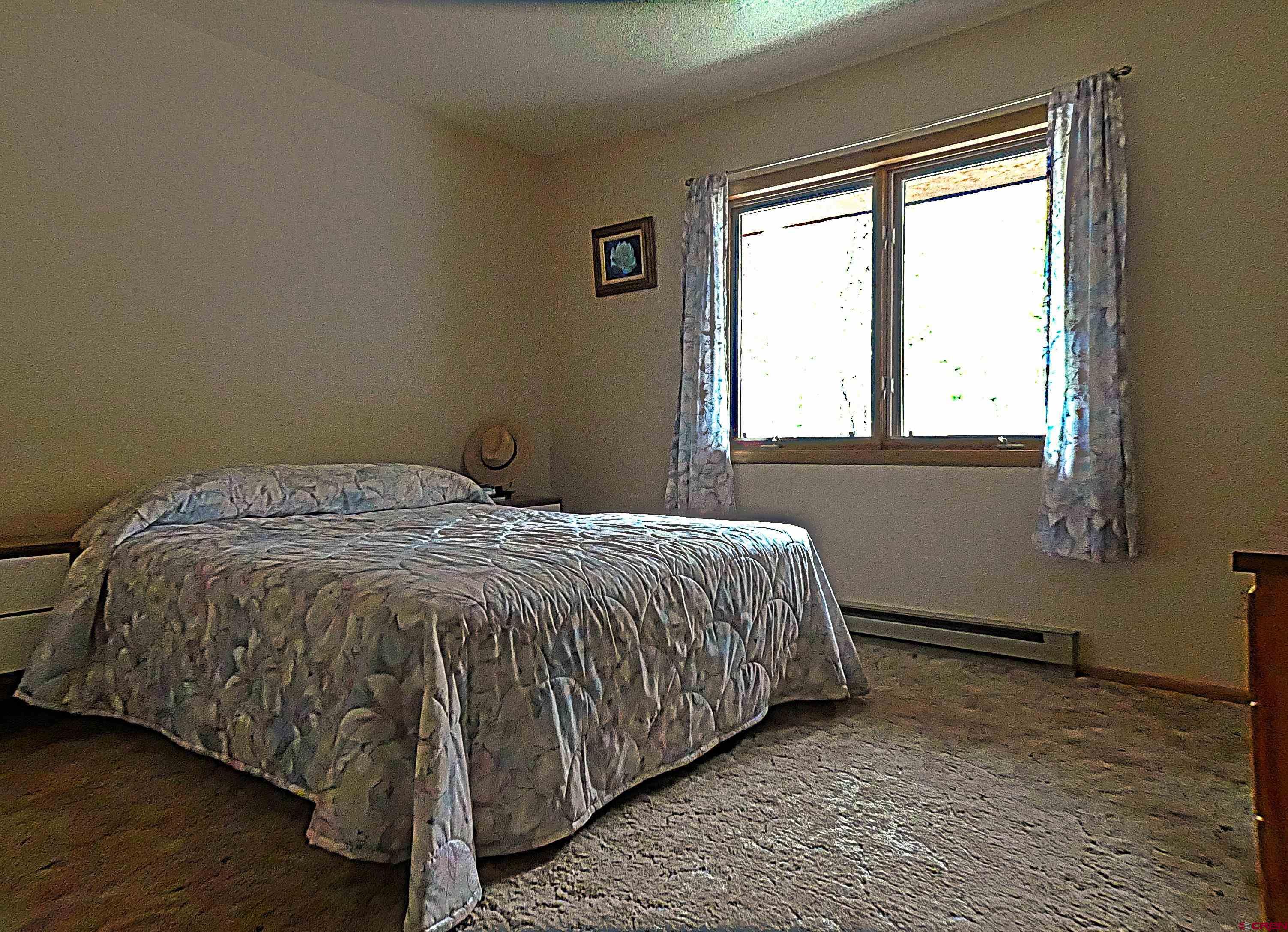 453 Ute Road Cimarron, CO 81220 - Photo 7 of 18 a bed sitting in a bedroom next to a window