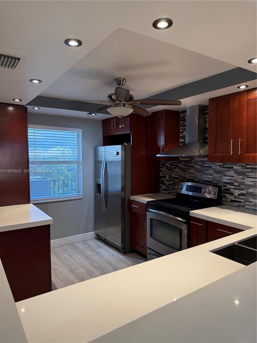 3910 Inverrary Boulevard, Unit 803B Lauderhill, FL 33319 - Photo 2 of 18 a kitchen with stainless steel appliances kitchen island granite countertop a refrigerator stove and sink