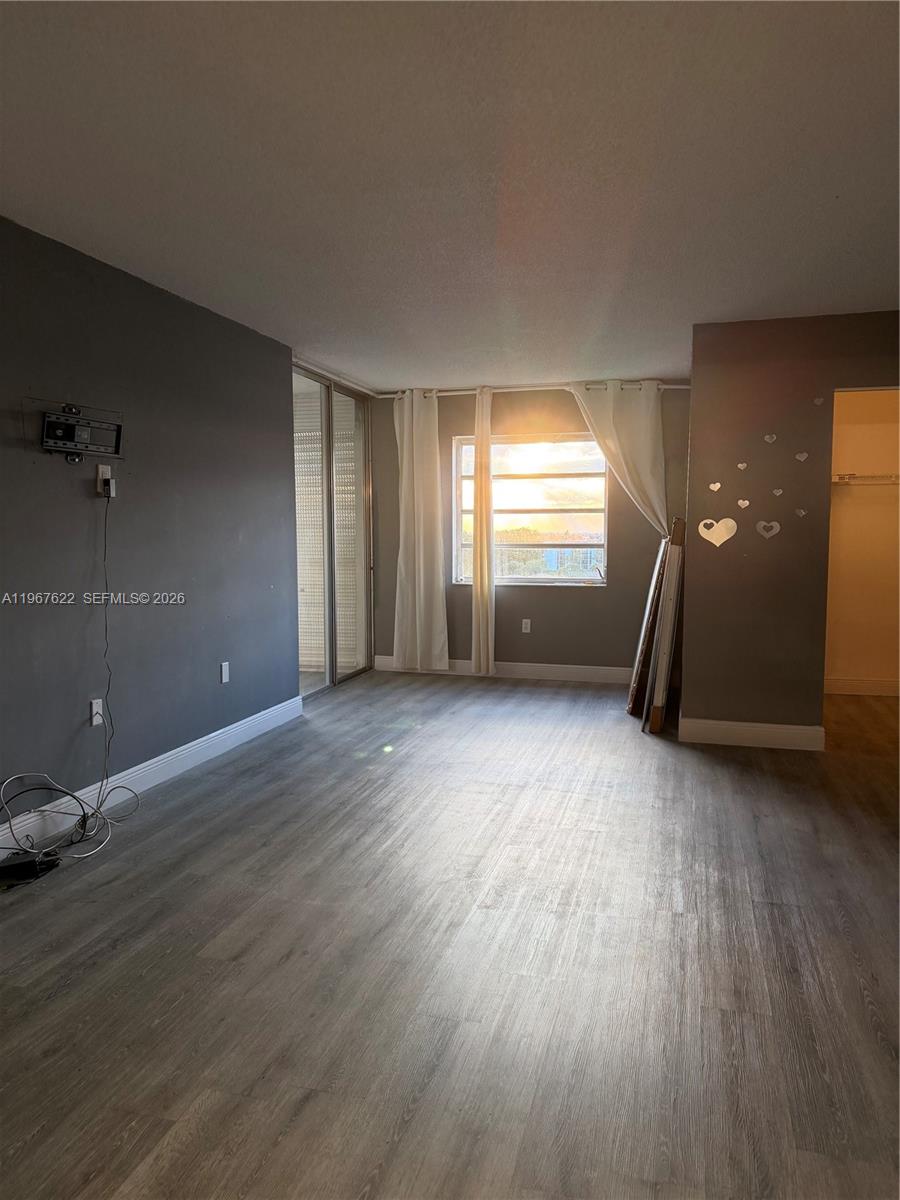 3910 Inverrary Boulevard, Unit 803B Lauderhill, FL 33319 - Photo 8 of 18 an empty room with wooden floor and windows