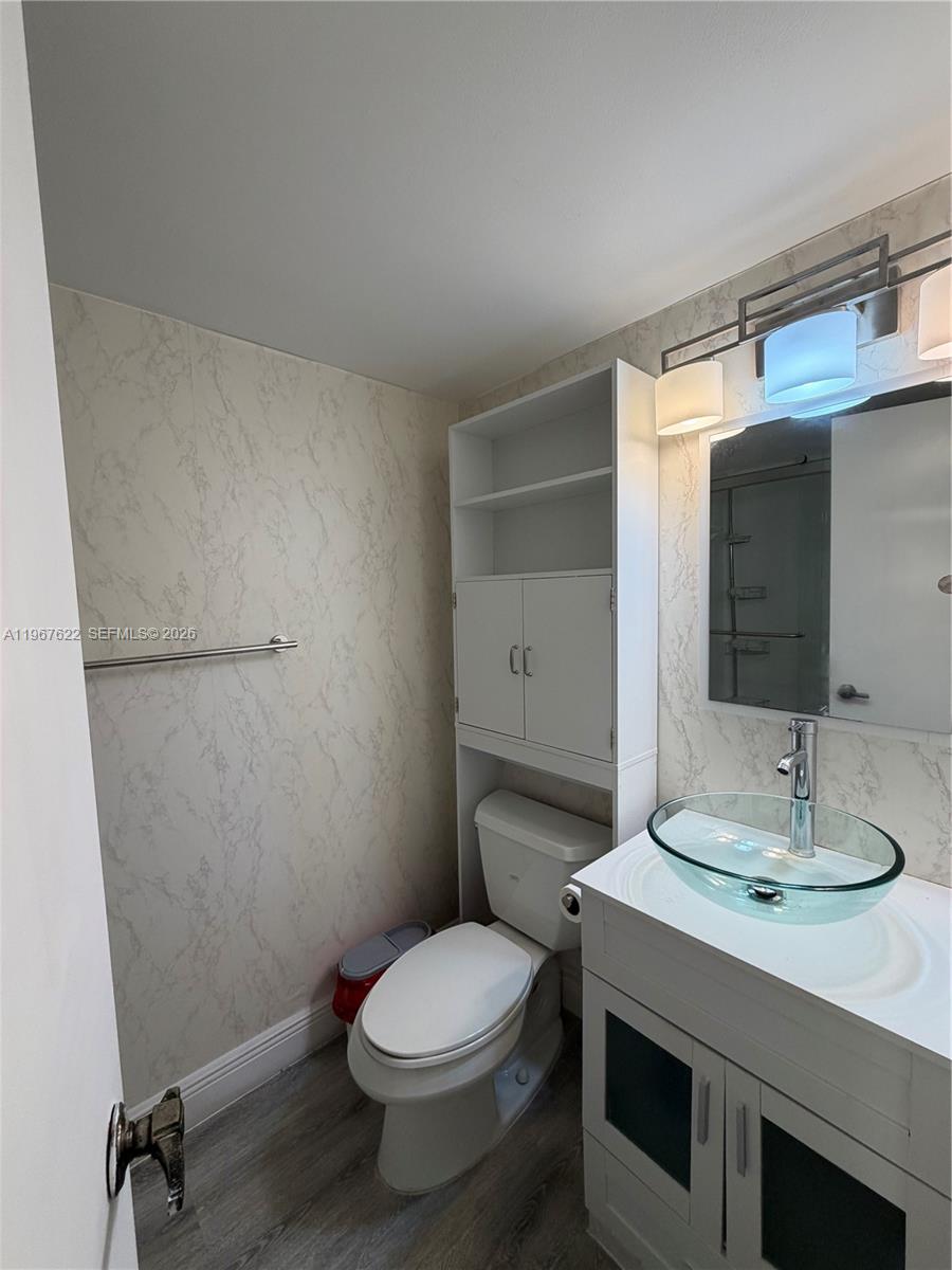 3910 Inverrary Boulevard, Unit 803B Lauderhill, FL 33319 - Photo 10 of 18 a bathroom with a sink a toilet and shower