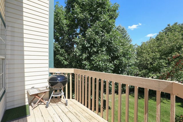 953 Ridgefield Lane Wheeling, IL 60090 - Photo 10 of 10 a balcony with wooden floor outdoor seating and trees in the background