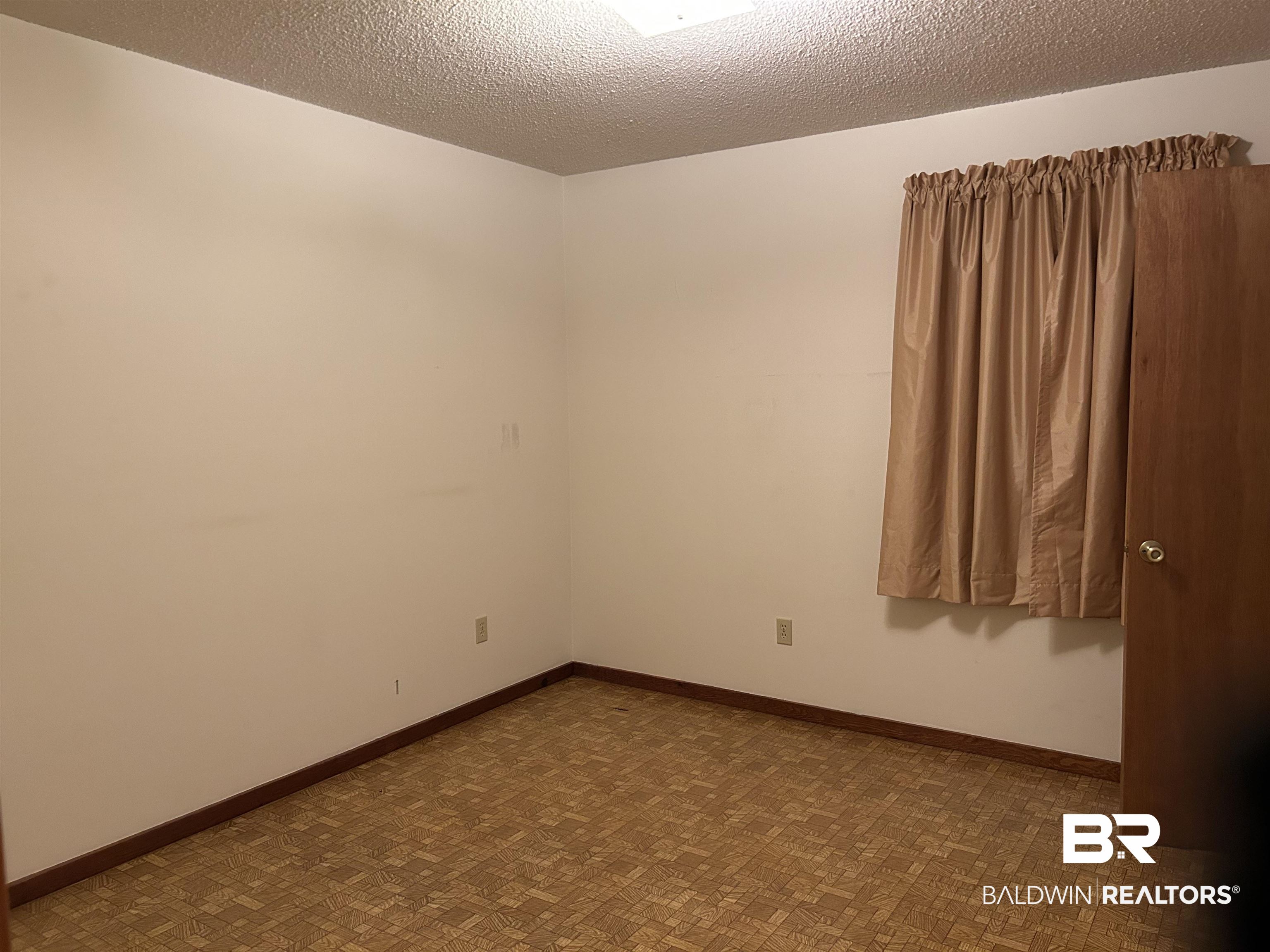 1350 A Schillinger Road South Mobile, AL 36695 - Photo 7 of 18 Spare room featuring a textured ceiling and baseboards