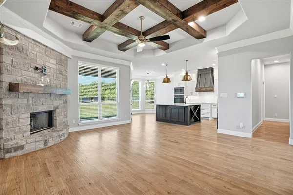 a view of a livingroom with wooden floor and a fireplace