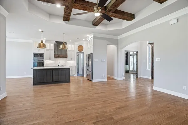 a view of a room with kitchen appliances and a ceiling fan