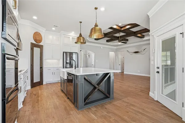 a kitchen with stainless steel appliances granite countertop a sink a stove and a wooden floors
