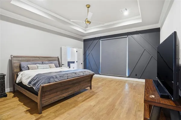 a bedroom with a bed and a flat tv screen on a dresser