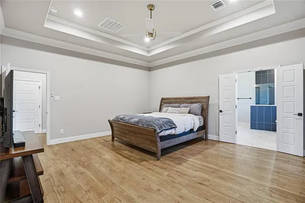 a bedroom with a bed and a flat tv screen on dresser