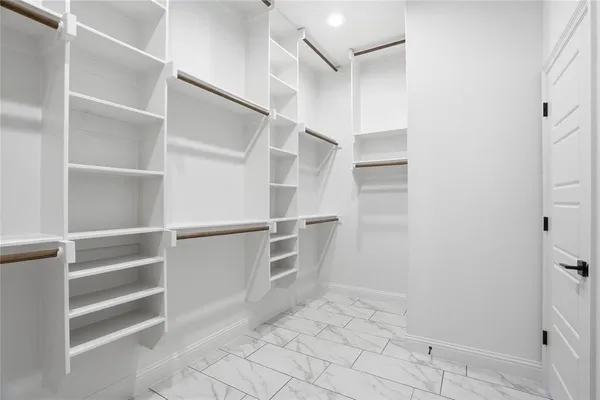 a view of walk in closet with empty racks