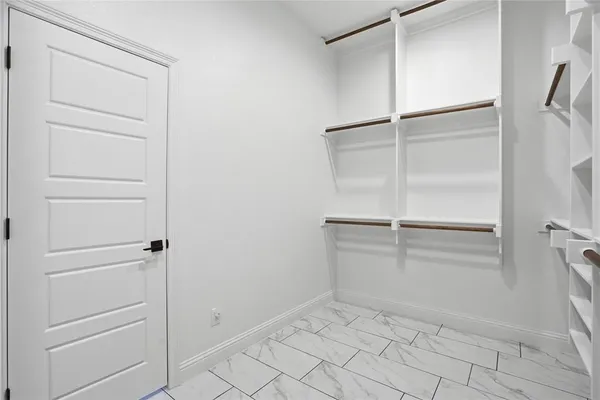 a view of walk in closet with empty racks