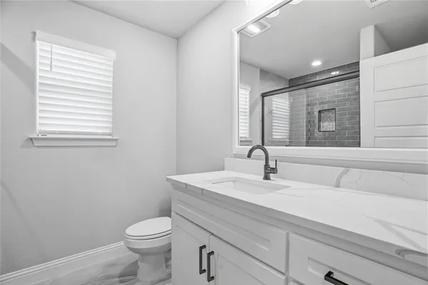 a bathroom with a sink a toilet and mirror