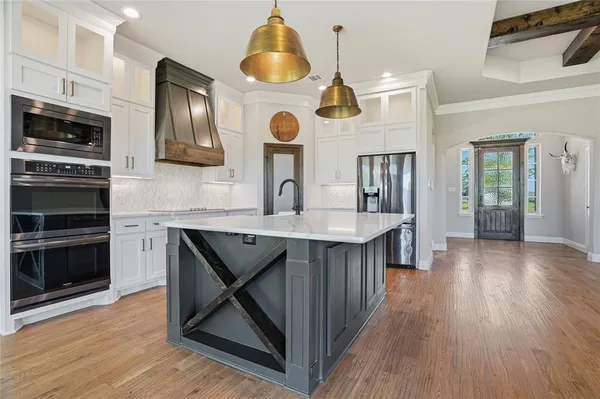 a kitchen with stainless steel appliances granite countertop a stove a sink and a microwave