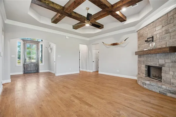 a view of empty room with wooden floor and fireplace