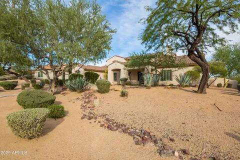 an aerial view of a house with a garden and lake view