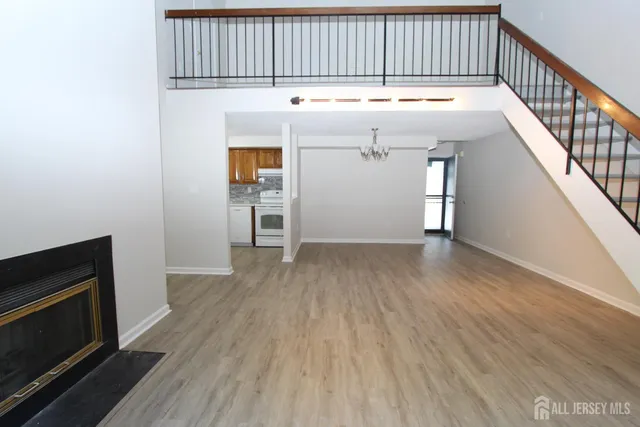 a view of a livingroom with wooden floor and staircase