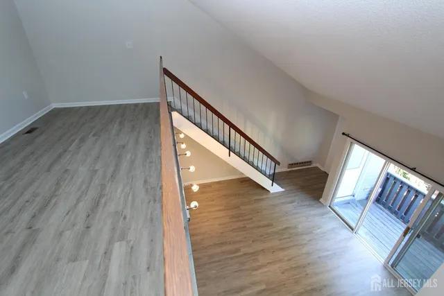 a view of a hallway with wooden floor and staircase