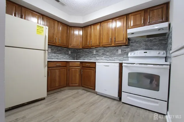a kitchen with granite countertop cabinets stainless steel appliances and wooden floor