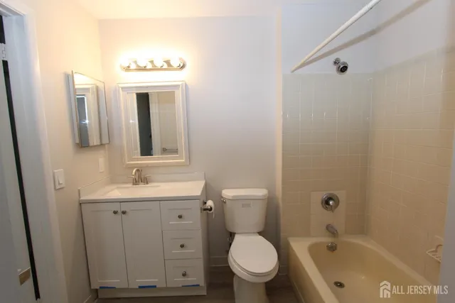 a bathroom with a toilet a sink and mirror