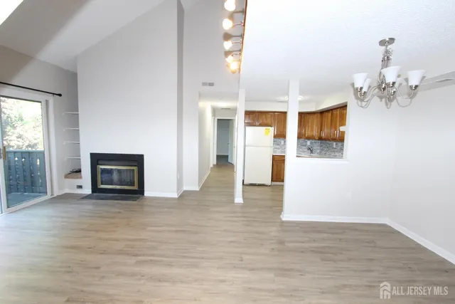 a view of a hallway with wooden floor and a kitchen