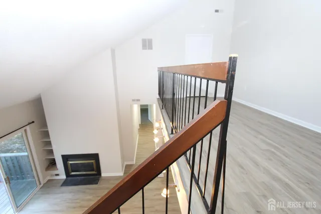 a view of a hallway with wooden floor and staircase