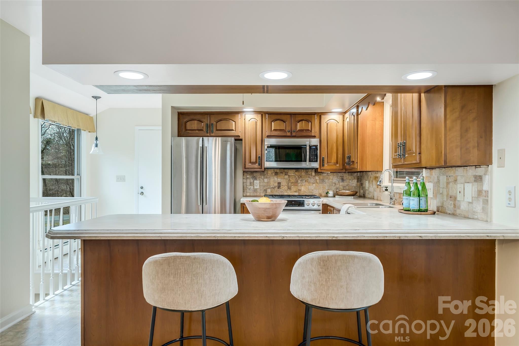 63 Pinecroft Road Asheville, NC 28804 - Photo 14 of 48 a kitchen with stainless steel appliances granite countertop a table chairs sink and cabinets