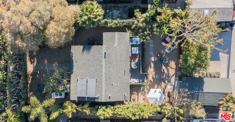 an aerial view of a house with a yard and large trees