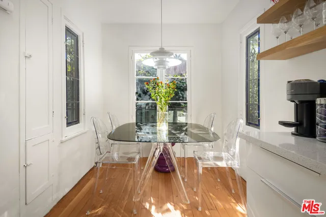 a dining room with furniture a potted plant and wooden floor
