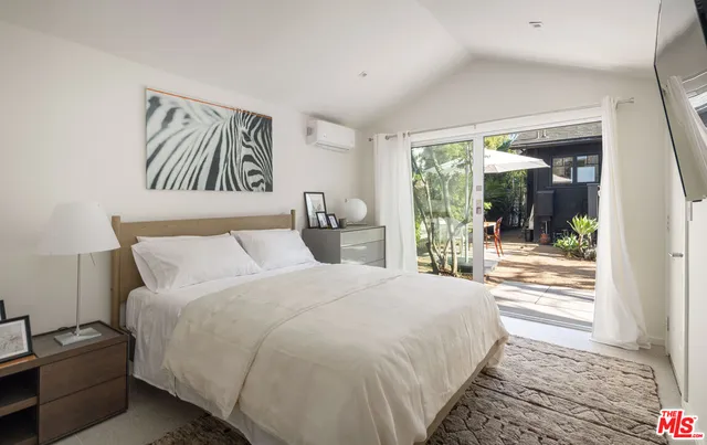 a bedroom with a bed and a large window