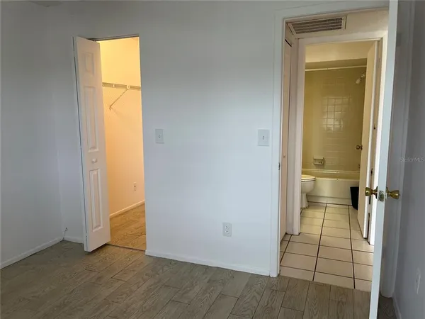 an empty room with a bathroom and a window