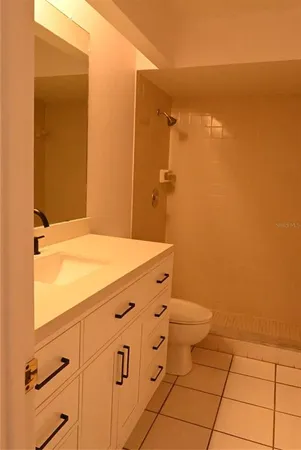 a bathroom with a granite countertop toilet and a sink