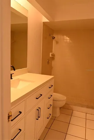 a bathroom with a granite countertop toilet and a sink