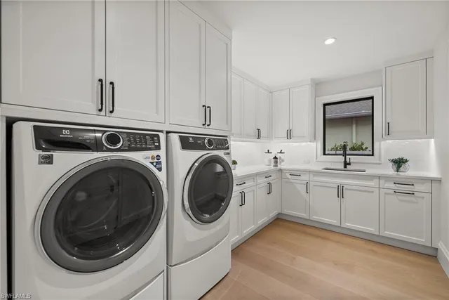 a kitchen with white cabinets and wooden floor