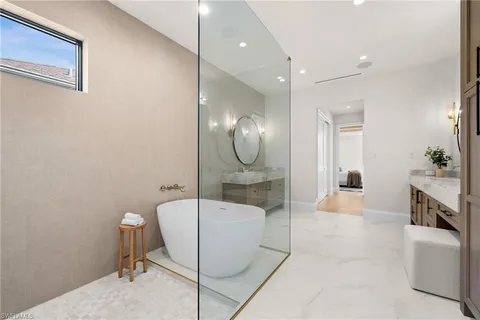 a spacious bathroom with a granite countertop sink mirror and bathtub