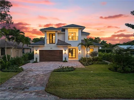 a front view of a house with a garden and yard