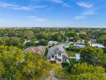 a view of a white house with a yard patio and a fire pit