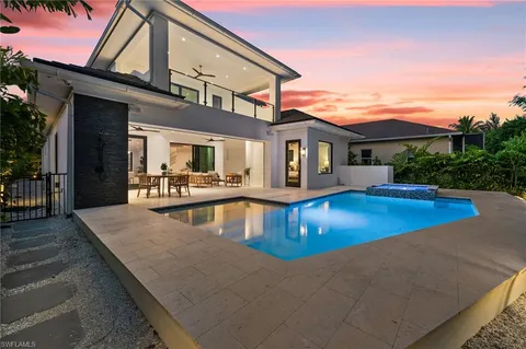 a view of a white house with a yard and plants