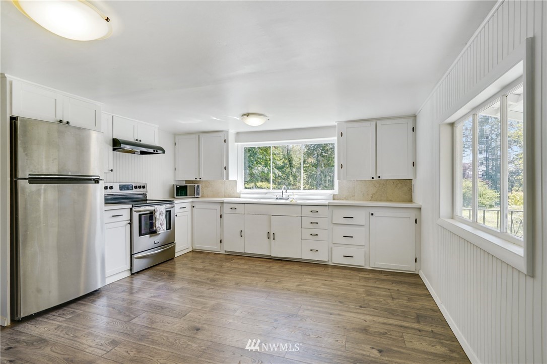 14019 Chain Lake Road Monroe, WA 98272 - Photo 6 of 32 a kitchen with white cabinets and stainless steel appliances