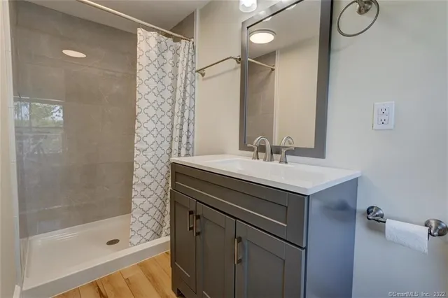 a bathroom with a shower sink and mirror