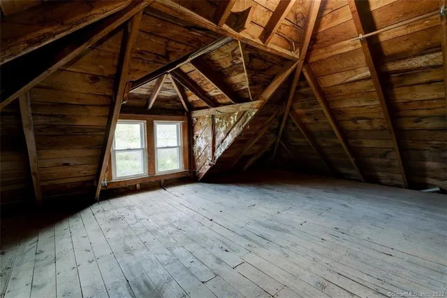 a view of an empty room with wooden floor and stairs